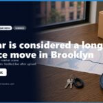 Alt text: A close-up of a map highlighting a route in Brooklyn, with a key and a moving wheel nearby, representing long-distance moving logistics. The image includes contact information for a moving service.