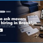 Image of a workspace featuring a tablet displaying moving truck listings, a miniature moving truck model, and documents with pre-hire questions for movers. The scene emphasizes the importance of asking the right questions before hiring moving services in Brooklyn.